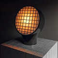 Modern Circular Grid Table Lamp With Warm Yellow Light On Gray Tiled Surface