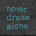 Stylish Blue Neon Decorative Light Displaying Never Dream Alone Against Black Background