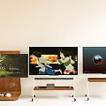 Three TVs Displaying Movie Poster Animated Scene And Earth Visualization On Wooden Metal Stands