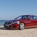 Various Cars Parked On Sandy Beach With Ocean And Blue Sky View