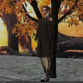 Woman In Brown Sweater With Long Black Hair Standing By Trees And Orange Autumn Leaves