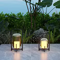 Outdoor Lantern Lights With Black Frame Illuminated On Stone Floor Among Green Plants