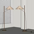Two Modern Floor Lamps With Light Colored Shades And Brass Poles By White Window Blinds