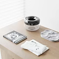 Black And White Circular Inflatable Device On Wooden Table With Magazine Towel And Gray Tray