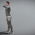 Man In Compression Sportswear Standing Against Gray Background Smiling With Right Hand Behind Neck