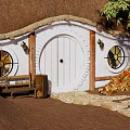 Cottage Entrance With Thatched Roof White Round Door Round Windows Bench And Stone Steps