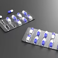 Blue And White Capsules In Blister Packs With Scattered Pills On Dark Surface