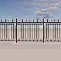Ornate Black Iron Fence With Pointed Tops Against Blue Sky And Gray Pavement