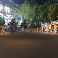 Night Outdoor Colorful Food Stalls with People Gathering Near Trees and Buildings