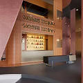 Hotel Lobby Interior Featuring Circular Fireplace Arched Window Pink Walls Sofas And Hanging Pendant Lights