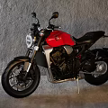 Modern Red and Black Motorcycle with Sleek Design Sporty Features in Gray Indoor Wall Setting