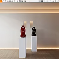Red And Black Sculptures Displayed On White Pedestals With Wall Lamps