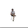 Man sitting on stool holding cup wearing white shirt shorts and sandals against white background