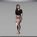 A woman wearing black top and pink skirt against gray background in standing pose