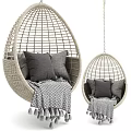 Rattan Egg Shaped Hanging Chair With Gray Cushions And Fringed Blanket