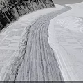 Snowy Terrain With Winding Tire Tracks Across Vast Smooth White Landscape