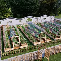 Serene Garden Landscape with Transparent Arched Greenhouses Wooden Frames Planter Boxes and Colorful Flowers