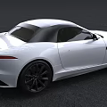 White Jaguar Convertible Sports Car With Black Top And Sleek Exterior Design