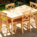 Outdoor Wooden Dining Table Set with Four Cross Back Chairs and Garden Grass Flowers