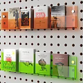 Transparent Bookshelf On Perforated Wall With Orange And Green Holders And Books