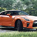 Orange Nissan GT-R Sports Car Parked In Green Grass With Trees Background