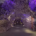 Cave Inspired Elevator Hallway with Rock Walls Purple White Lighting Dark Floor and End Door