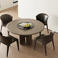Modern Round Dining Table Set with Four Dark Chairs and Fruit Tray in Indoor Area