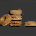 Golden Brown Sesame Seed Bagels Stacked and Single on Black Surface
