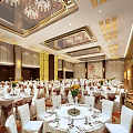Elegant Banquet Hall with Luxurious Ceiling Chandeliers White Tablecloths Floral Centerpieces and White Chairs