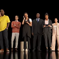Group of Multiethnic People in Different Outfits Standing and Using Devices Against Black Background