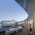 Modern Commercial Street Featuring Curved Architecture Waterfront Deck Outdoor Seating And Pedestrians