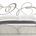 Elegant Double Bed With Curved Metal Headboard White Bedding Dark Blanket And Bedside Tables