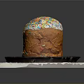 Traditional Sweet Bread With White Frosting And Colorful Sprinkles On Black Plate And White Mat
