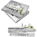 Stacked Art And Beauty Books With White Flowers And Green Leaves
