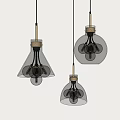 Three Modern Glass Pendant Lights With Transparent Shades And Visible Bulbs