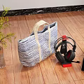 Wireless Headphones And Portable Speaker With Striped Tote Bag And Vase On Wooden Floor