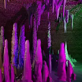 Colorful Cave Interior With Purple Green Illuminated Stalactites And Stalagmites