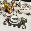 Elegant Golden Dinnerware Set With Black Placemats Candle Holders And Fruit Jars