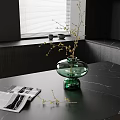 Green Glass Vase With Flower Branches On Black Marble Tabletop Near Magazine And Window