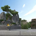 Traditional Garden Scene With Rock Formations Pine Tree Stone Lantern Wooden Chair And Green Plants