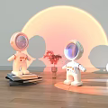White Spherical Table Lamp With Astronaut Figurines Orange Circular Background And Small Potted Plant