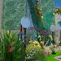 Floral Installation With Woman In White Dress Green Marble Waterfall Colorful Flowers And Curved Arch