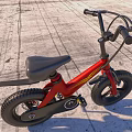 Red Balance Bike With Large Wheels Black Seat And Yellow Accents In Outdoor Field
