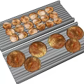 Fresh Round Bread Loaves on Metal Baking Grills with Golden Brown Crusts