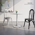 Modern White Round Dining Table Set with Black White Chairs Green Plant and Wall Art