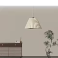 Pleated Cream Pendant Light Hanging In Interior With Light Gray Wall And Green Plant