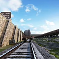Utility Vehicle on Railway Track Alongside Stone Wall and Manual Tunnel Entrance