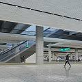 Modern Station Interior Space With Open Ceiling Design Green Direction Signs Concrete Columns And Pedestrians