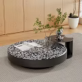 Round Coffee Table With Black And White Patterned Top Open Book Transparent Vase Green Plant