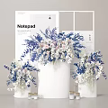 Elegant Modern Floral Display with Blue White Blooms in White Cylindrical Vessels and Small Candles